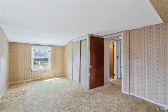 spare room with carpet floors and wallpapered walls