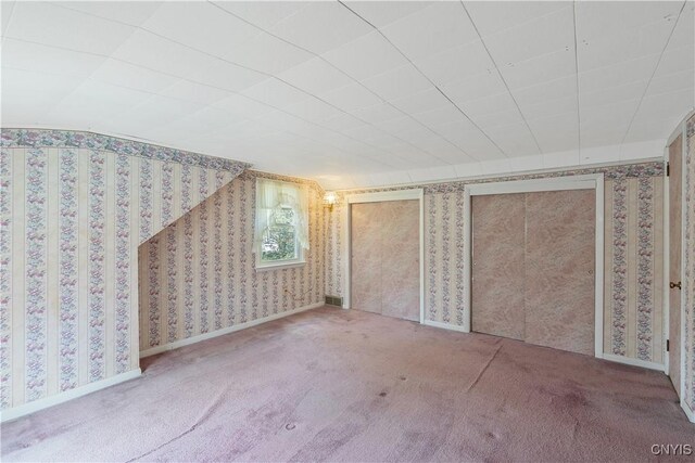 additional living space with carpet floors, visible vents, and wallpapered walls
