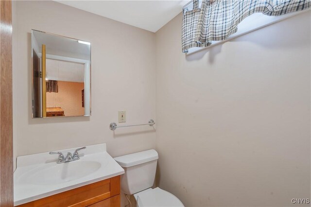 half bathroom featuring vanity and toilet