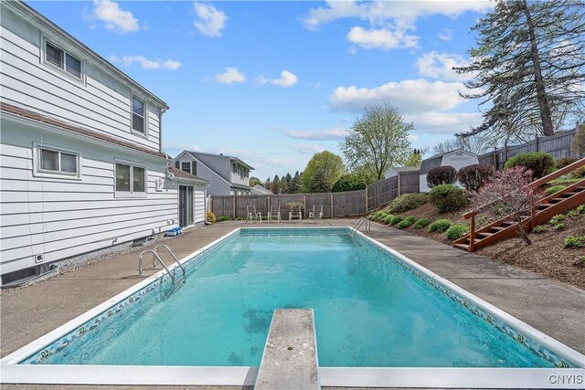 view of pool featuring a diving board, stairs, a fenced backyard, a fenced in pool, and a patio