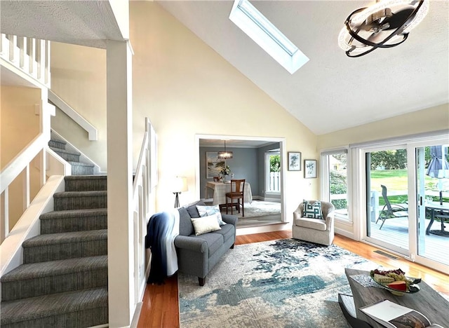 living room featuring visible vents, stairs, wood finished floors, and high vaulted ceiling