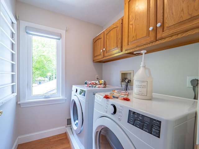 laundry area with washer and dryer, light wood-style floors, baseboards, and cabinet space
