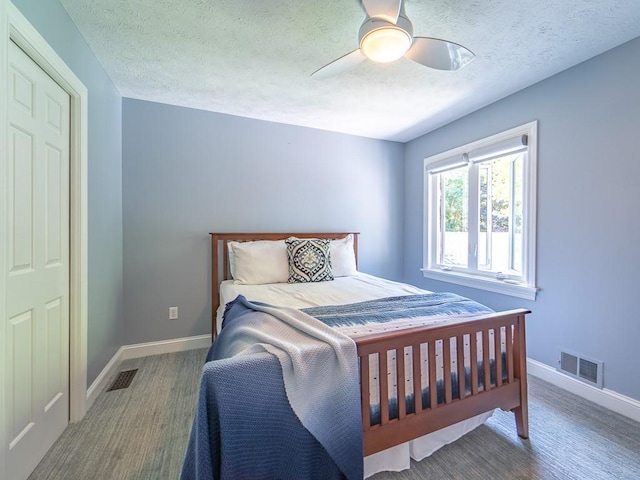 bedroom featuring visible vents, a textured ceiling, baseboards, and a ceiling fan
