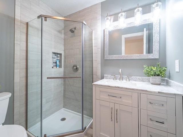 full bath featuring vanity, toilet, and a stall shower
