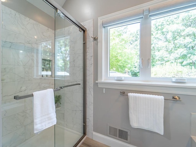 bathroom featuring baseboards, a stall shower, and visible vents