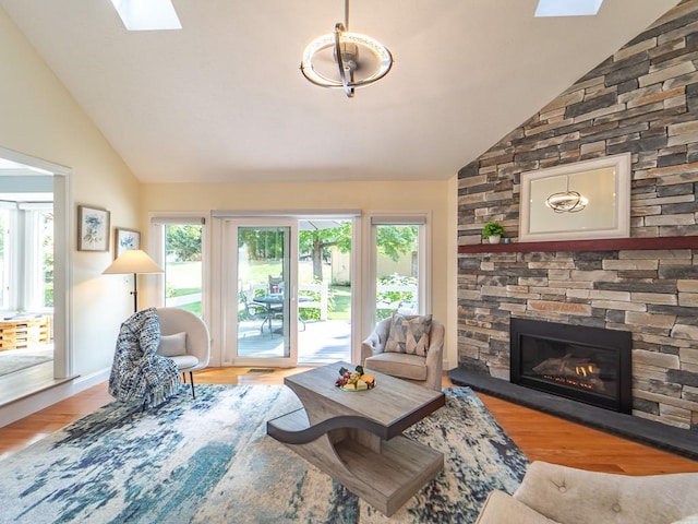 living room with a skylight, a fireplace, wood finished floors, and a wealth of natural light