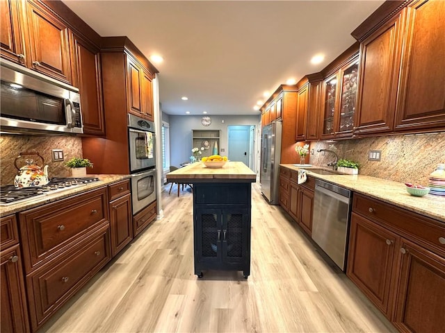 kitchen featuring stainless steel appliances, recessed lighting, a sink, and light wood-type flooring