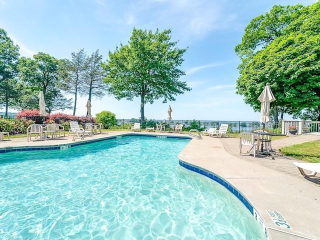 community pool featuring fence and a patio area