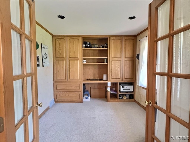 unfurnished office featuring built in study area, light carpet, french doors, and baseboards
