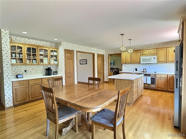 dining area featuring recessed lighting, wallpapered walls, and light wood-style floors