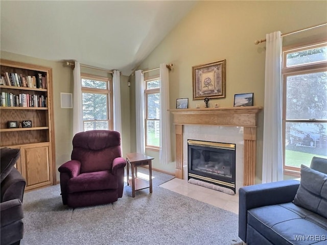 living room with vaulted ceiling, a fireplace with flush hearth, and carpet floors