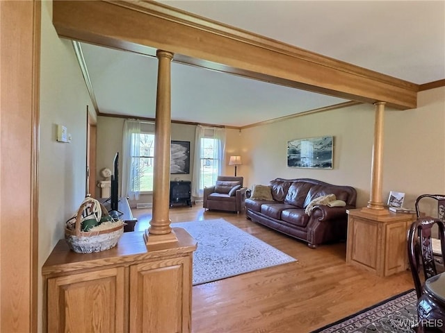 living room featuring light wood-style floors, a fireplace, and ornamental molding