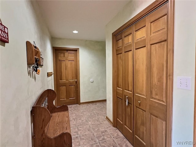 hall with baseboards, light tile patterned flooring, and recessed lighting