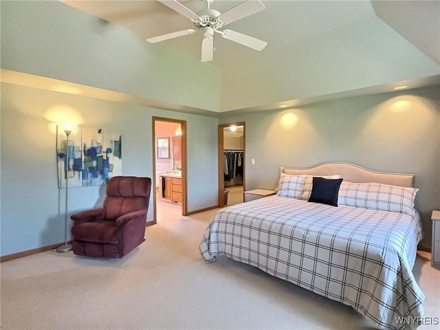 bedroom with baseboards, connected bathroom, high vaulted ceiling, a walk in closet, and light carpet