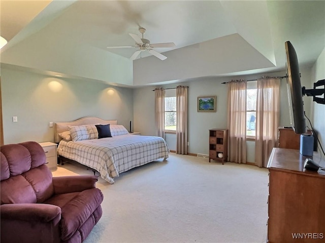 carpeted bedroom featuring a wood stove, lofted ceiling, and ceiling fan