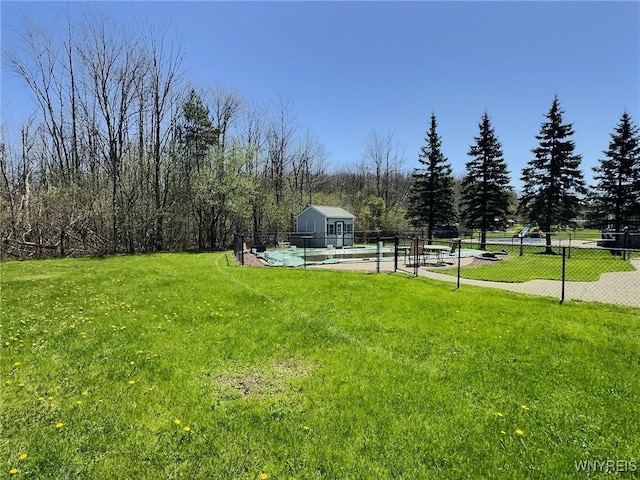 view of yard with fence, a fenced in pool, and an outdoor structure