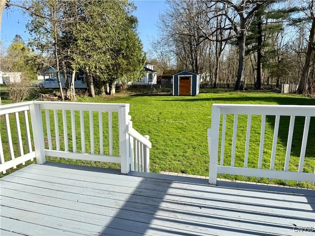deck featuring a storage unit, an outbuilding, and a yard