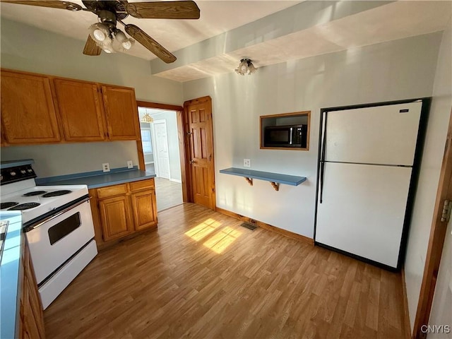 kitchen with light wood-style floors, a ceiling fan, brown cabinets, and white appliances
