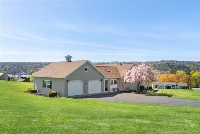view of front of house with an attached garage, driveway, and a front yard