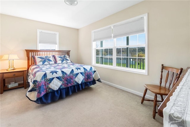 bedroom with baseboards and light colored carpet