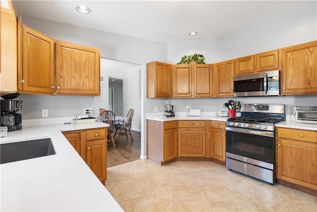 kitchen with light countertops, stainless steel appliances, recessed lighting, and a toaster