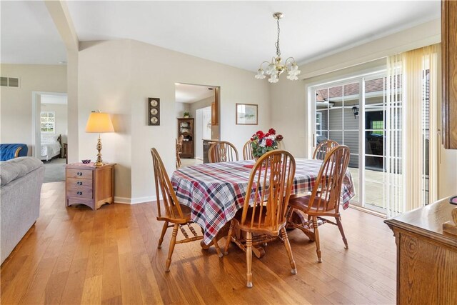 dining space featuring baseboards, an inviting chandelier, plenty of natural light, and light wood finished floors