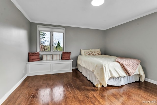 bedroom featuring baseboards, visible vents, ornamental molding, and wood finished floors