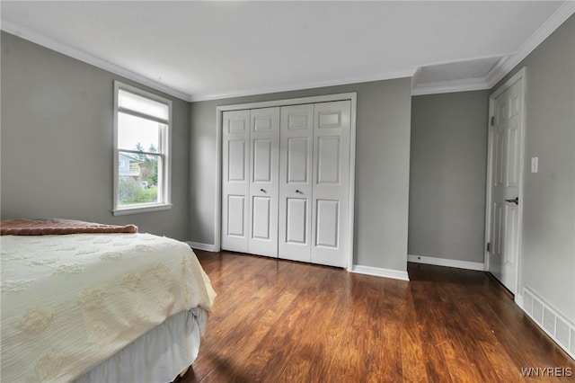 bedroom with dark wood finished floors, ornamental molding, visible vents, and a closet