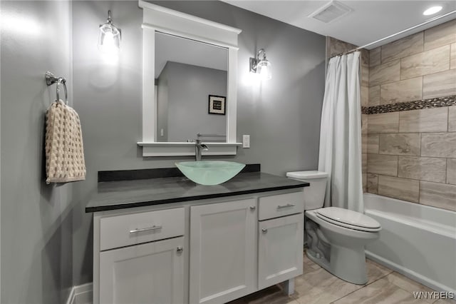 bathroom featuring visible vents, shower / tub combo, toilet, and vanity