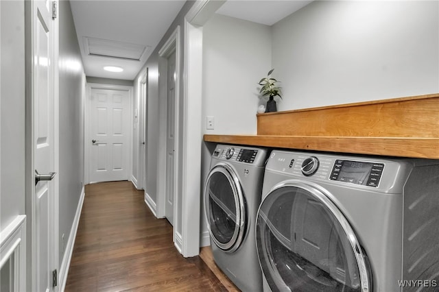 clothes washing area with laundry area, attic access, dark wood finished floors, baseboards, and washer and clothes dryer