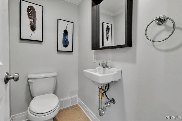 bathroom featuring visible vents, tile patterned flooring, baseboards, toilet, and ornamental molding