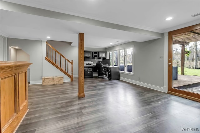 unfurnished living room featuring dark wood finished floors, stairway, baseboards, ornamental molding, and recessed lighting
