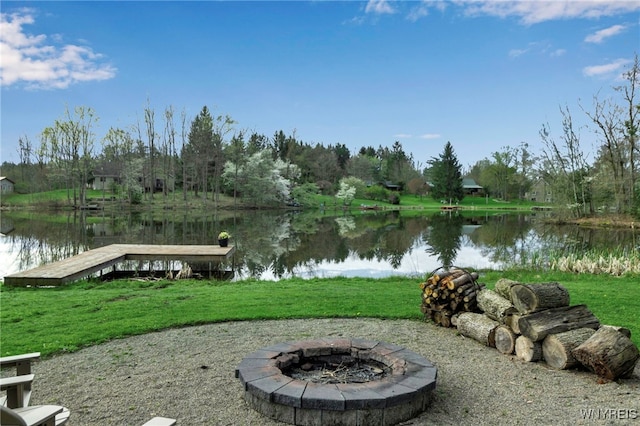 view of yard with a boat dock, an outdoor fire pit, and a water view