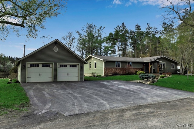 ranch-style house with an outdoor structure, a front yard, and a garage