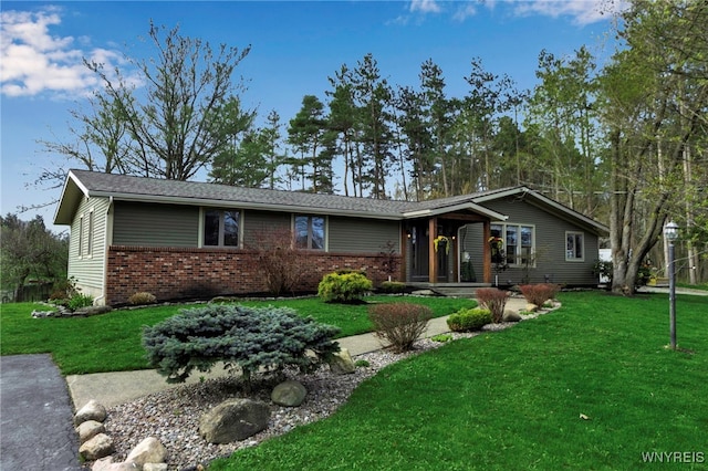 ranch-style house featuring brick siding and a front lawn