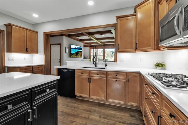 kitchen featuring a sink, light countertops, stainless steel appliances, dark wood-type flooring, and coffered ceiling