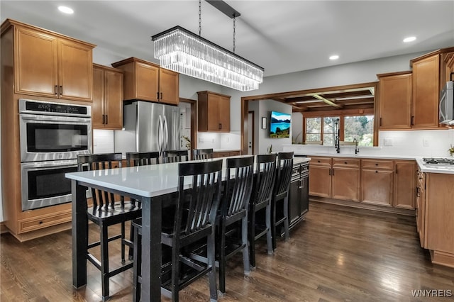 kitchen with an inviting chandelier, stainless steel appliances, recessed lighting, decorative backsplash, and dark wood-type flooring
