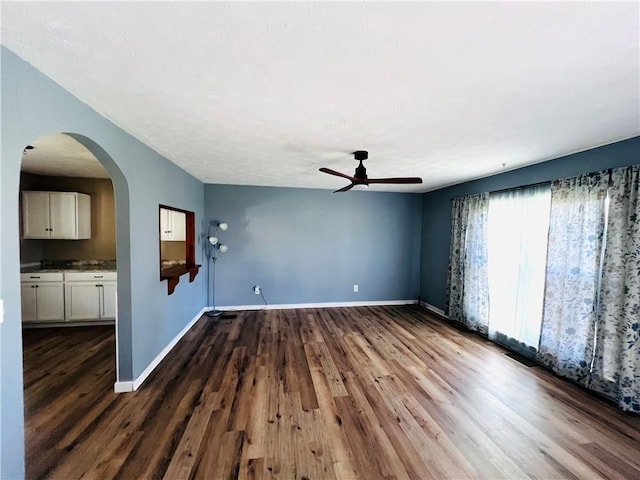 71 Redwing Ln, Horseheads, NY 14845 - interior space featuring baseboards, a ceiling fan, dark wood-style flooring, and arched walkways