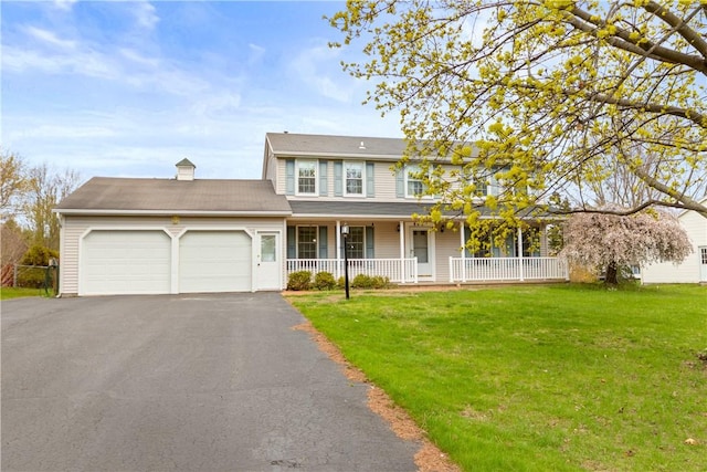 view of front of house featuring a garage, a front lawn, covered porch, and driveway