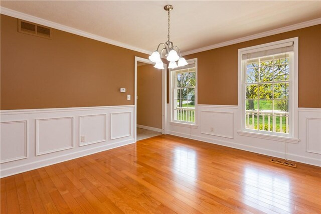 unfurnished room with visible vents, a notable chandelier, and a wealth of natural light