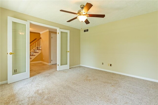 empty room with ceiling fan, french doors, visible vents, carpet floors, and baseboards
