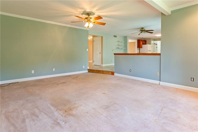carpeted empty room featuring baseboards, a ceiling fan, visible vents, and ornamental molding