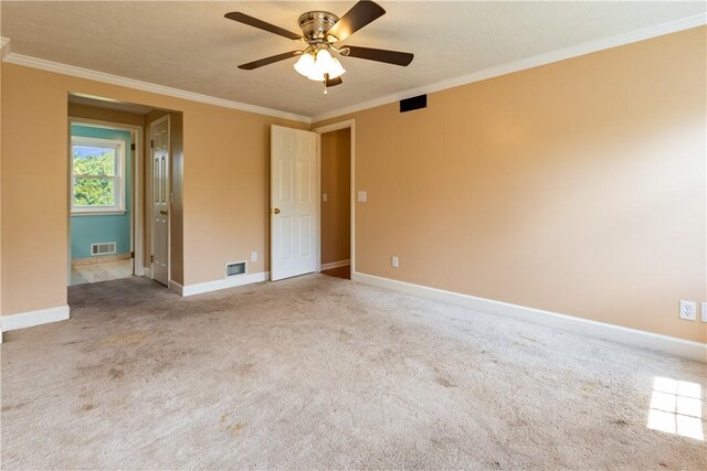 unfurnished bedroom with carpet floors, visible vents, and ornamental molding