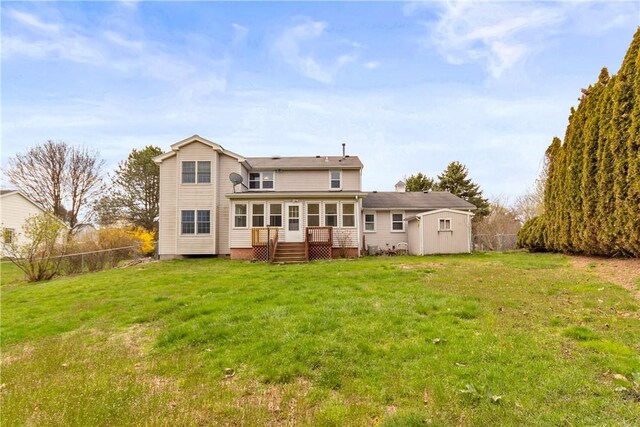 back of property with a fenced backyard, a yard, a shed, and an outbuilding