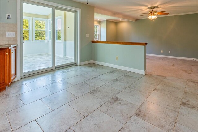 unfurnished room featuring a ceiling fan, baseboards, and plenty of natural light