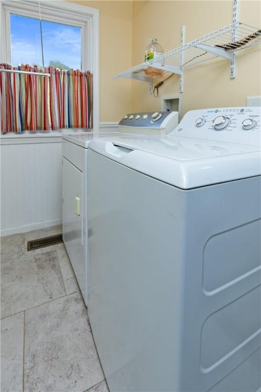 washroom featuring laundry area, visible vents, and washing machine and dryer