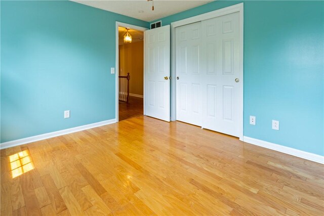 unfurnished bedroom featuring baseboards, visible vents, and light wood-style flooring