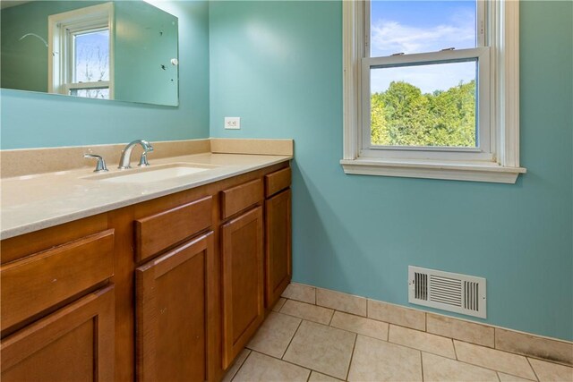 bathroom with visible vents, baseboards, tile patterned flooring, and vanity