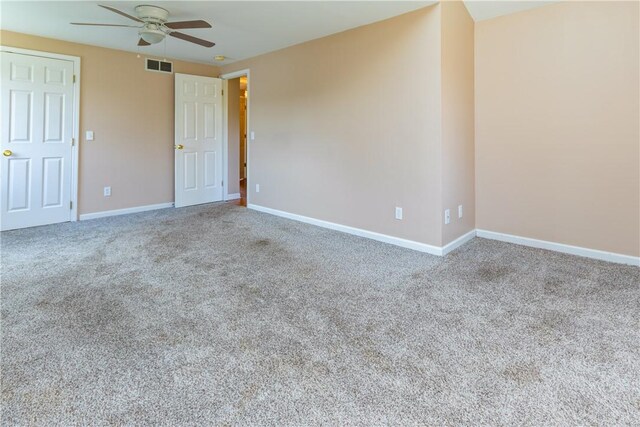 carpeted empty room featuring a ceiling fan, baseboards, and visible vents
