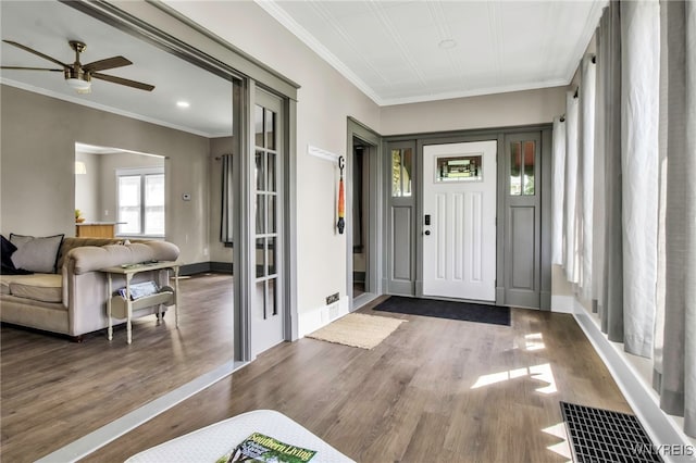entryway featuring visible vents, a ceiling fan, crown molding, and wood finished floors